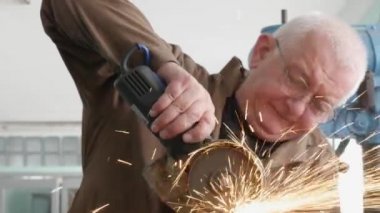 Endüstriyel atölyede çalışırken açı öğütücü kullanarak metal kesme mühendisi. Bir açı öğütücü ile metal kesim sırasında kıvılcım. 