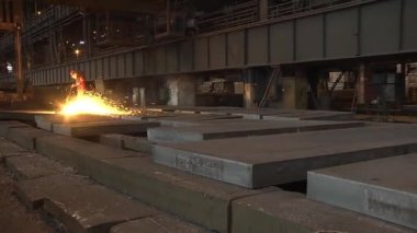 Bir çalışan metalurji tesisinde sac haddeleme yapar. Frezeleme bitmiş metal.