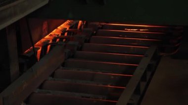 Çelik fabrikası, çelik levha üretimi, sıcak levhaların üretim hattında taşınması, ağır sanayi, metal haddeleme tesisi. Konveyör hattı metal haddehane. Yakın çekim.