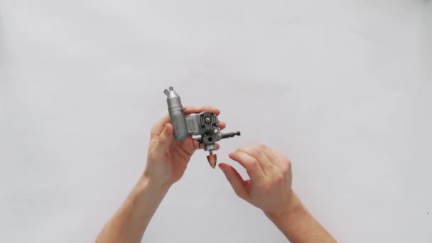 オートレースやエアレース用のマイクロモーターを持つ若い男性エンジニアの手 ガスグローエンジン — ストック動画