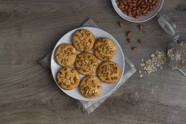 Gri ahşap arka plan üzerinde tabakta fıstık ile sağlıklı yulaf ezmesi çerezleri, üst görünümü