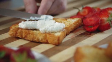Taze kırmızı çilek ve beyaz süzme peynir sandviç ahşap bir tahta üzerinde, yakın, Yavaş yavaş odaklanarak. Çilekli sandviç pişirme işlemi. Helthy gıda. 