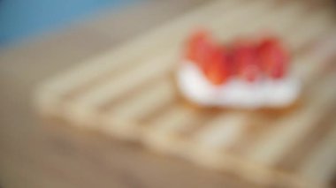 Kırmızı çilek ve beyaz süzme peynir sandviç ahşap bir tahta üzerinde, yakın. Yavaş yavaş taze kırmızı çilek sandviç odaklanarak. Helthy gıda. 