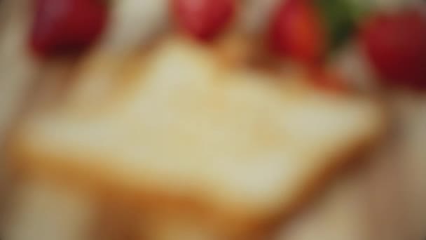 女人的手把奶酪铺在烤白面包上 草莓三明治烹调工艺 好喝的食物 靠近点 — 图库视频影像