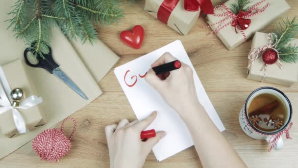 Mujer Mano Escribiendo Una Lista Objetivos Mesa Madera Con Regalos — Vídeo de stock