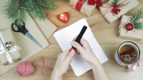 Mujer Escribiendo Mano Una Lista Deseos Mesa Madera Con Regalos — Vídeo de stock