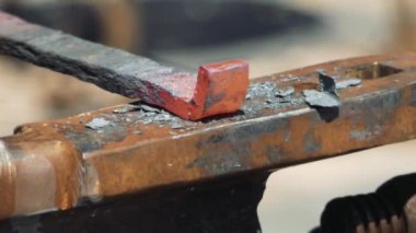 Smith örs üzerinde kanca kırmızı sıcak demir oluşturan. Demirci dövme örs üzerinde çekiç sıcak metal yener. Smithy sokakta. Yavaş çekim, yakın çekim.