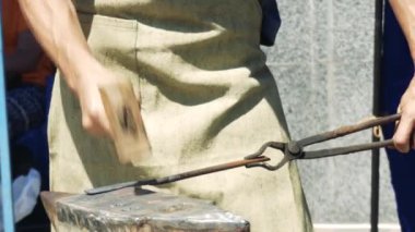 Anvil üzerinde Massive Hammer Banging Hot Metal Bar Holding Bir Demirci. 