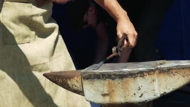 铁匠拿着一个巨大的锤子敲打热金属棒在铁锤 — 图库视频影像
