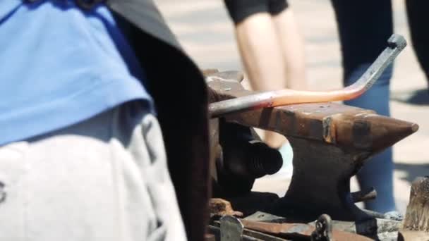 铁匠拿着一把巨大的锤子敲打铁锤上的热金属棒 史密斯在街上特写 — 图库视频影像