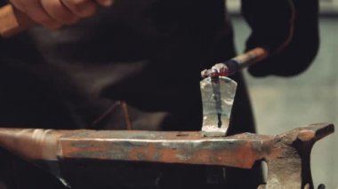 Anvil'de Bir Demirci Metal Çubuğu Kesmek için Hardy Kesme Aracı kullanıyor. Demirci, kıvılcım havai fişeklerle demircide erimiş metali elle dövülerek