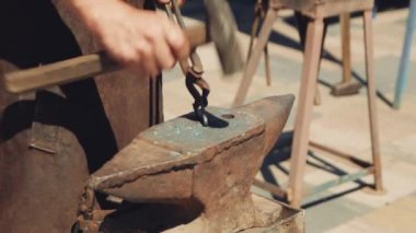 Demirci elle metalden bir kalp dövüldü. Çekiç ve maşalarla metal bir kalbin şeklini düzeltir..