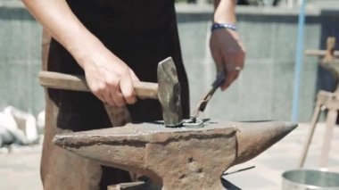 Demirci elle metalden bir kalp dövüldü. Çekiç ve maşalarla metal bir kalbin şeklini düzeltir..