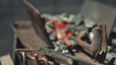 Hot Metal Bar Close Up Alev ile Demirci Dükkanı'nda bir Kömür Forge ısıtmalı olmak. Metal parçalar fırında ısıtılır ve demirci atölyesinde dövme için hazırlanır