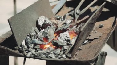 Hot Metal Bar Close Up Alev ile Demirci Dükkanı'nda bir Kömür Forge ısıtmalı olmak. Metal parçalar fırında ısıtılır ve demirci atölyesinde dövme için hazırlanır