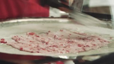Dondurma tavada çilek ile tavada tavada tavada tavada tavada tavada tavada tavada tavada kızartılmış dondurma ruloları hazırlıyoruz. Haddelenmiş dondurma, el yapımı dondurma tatlısı. Çelik soğutulmuş tava ile kızarmış dondurma makinesi.