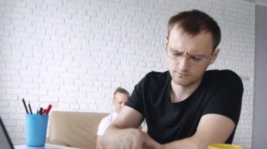 Yakın Çekim'de konuşurken telefonla konuşan beyaz bir adamın dizüstü bilgisayarın önünde gülümseyip gülerek yaptığı portre. Kavram serbest çalışma, iş, iletişim, eğitim. 