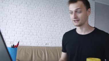 Mutlu genç kafkas adam evde dizüstü bilgisayarda sohbet. İletişim, serbest çalışma veya eğitim kavramı.