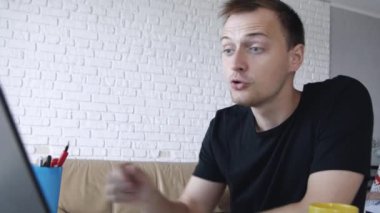 Kızgın genç beyaz adam evde dizüstü bilgisayarda sohbet. İletişim, serbest çalışma veya eğitim kavramı.