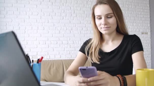 年轻的白种人长发女孩的肖像微笑着显示绿色屏幕的智能手机到相机在家庭办公室 — 图库视频影像