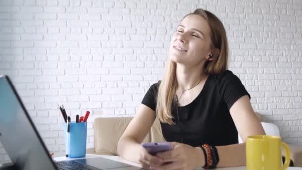 年轻的成功的白人妇女用耳机在电脑上听音乐 在家庭办公室跳舞 特写肖像 — 图库视频影像