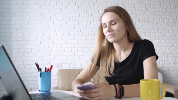 年轻的成功的白人妇女听摇滚乐在电脑上耳机 在家庭办公室跳舞 特写肖像 — 图库视频影像