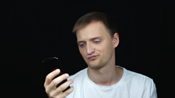 Молодой Кавказский Мужчина Сосредоточился Глядя Экран Телефона Закрыть Портрет Безразличный — стоковое видео