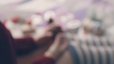 Genç kadın elleri tutar ve rahat ev kapalı dizlerinin üzerinde bir köknar ağacı koni döner. Genç kız şenlikli tatil sezonu için hazırlanıyor. Kroma anahtar akıllı telefon teknolojisi.