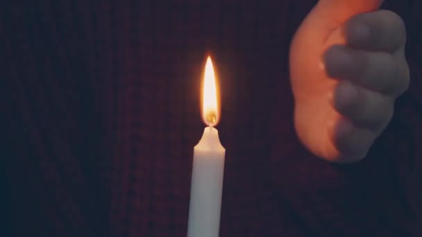 黒い背景に女性の手でろうそくを燃やす 暗闇の中でろうそくを燃やしている若い女性 ろうそくで祈る物乞いの概念 — ストック動画