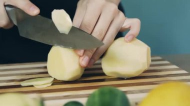 Kesme tahtasında patates kesme. Yakından kapatın. Patates halkası. Salata için sebze kes. Sağlıklı gıda.