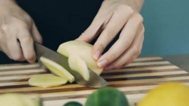 Kesme tahtasında patates kesme. Yakından kapatın. Patates halkası. Salata için sebze kes. Sağlıklı gıda.