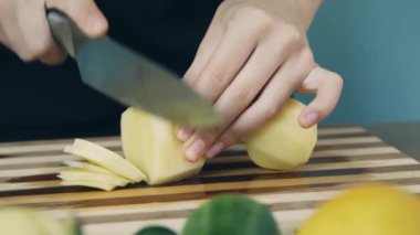 Kesme tahtasında patates kesme. Yakından kapatın. Patates halkası. Salata için sebze kes. Sağlıklı gıda.