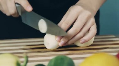 Aşçı tahta bir doğrama tahtasıüzerinde soğan kesme. Kadın el masada beyaz soğan kesme yakın. Soğan halkası. Salata için sebze kes. Sağlıklı gıda.