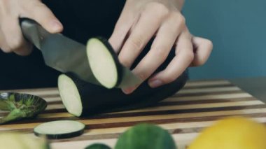 Tahta tahtada patlıcan kesen kadının elleri. Yakından kapatın. Patlıcan halkası. Salata için sebze kes. Sağlıklı gıda.