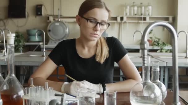 研究室で働く若い女性科学者の肖像化学教室でカメラを見ている悲しい化学者の学生 — ストック動画