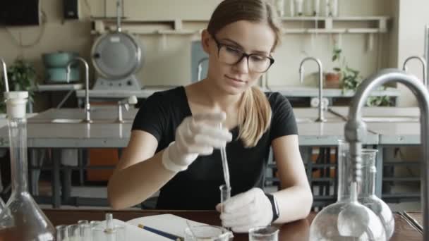 严肃的化学家学生正在做她的研究 化学课堂上年轻女子的肖像 — 图库视频影像