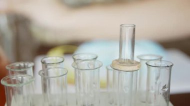Bir üniversite / okul laboratuvarında, pipet li bir öğrenci test tüplerinde bir sıvıanaliz eder. Kavram: araştırma, biyokimya, çalışma, kimyager