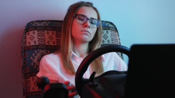 退屈な若い女性ゲーマーは レースシミュレータでオンラインビデオゲームをプレイします コンピュータシミュレーション — ストック動画