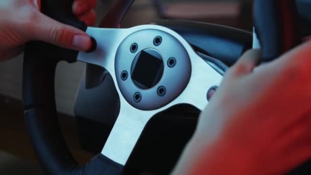 赛车模拟器和按钮方向盘后面一位年轻玩家的手的特写镜头 年轻的玩家享受赛车视频游戏与车轮 计算机模拟 — 图库视频影像