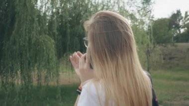 Gözlüklü mutlu kadın cep telefonuyla konuşuyor, dışarıda. Beyaz bir kız parkta yürürken telefonda konuşuyor. Parkta yürürken cep telefonuyla konuşan çekici genç kadın.