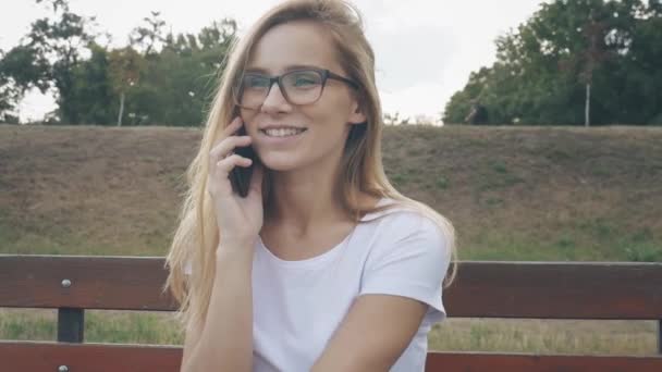 Mujer Feliz Con Teléfono Sienta Banco Parque Verano Joven Mujer — Vídeos de Stock