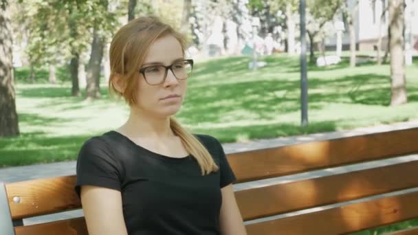 Mujer Bonita Gafas Mira Cámara Bosteza Chica Atractiva Sienta Banco — Vídeos de Stock