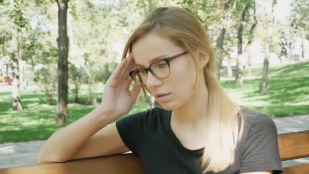 Young Woman Eyeglasses Headache Sitting Bench City Park Caucasian Girl — Stock Video