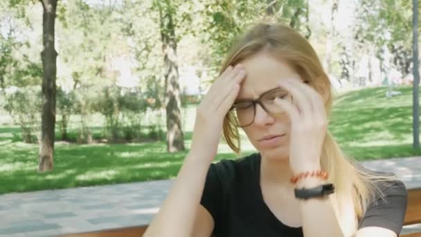 Eine Junge Frau Mit Brille Und Kopfschmerzen Sitzt Auf Einer — Stockvideo