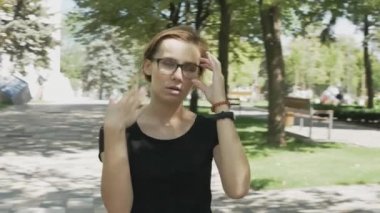 Gözlüklü ezilmiş beyaz kadın sıcak bir yaz günü parkta yürürken terleme ve sıcak inme acı