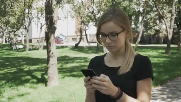 Mujer Caucásica Perpleja Gafas Caminando Comprobando Contenido Del Teléfono Inteligente — Vídeo de stock