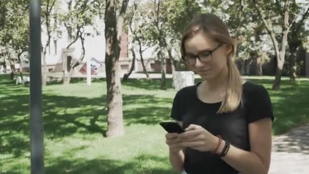 Mladá Kavkazská Žena Brýlích Která Chodí Kameře Kontroluje Telefon Oslavuje — Stock video