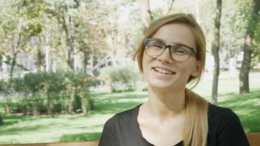 Kameraya bakan doğada mutlu bir genç beyaz kadının yakın yüzü. Şehir parkında neşeli bir kız. Parkta uzun saçlı sarışın bir gülen kadının açık hava portresi. Kopyalama alanı