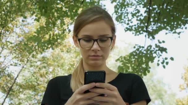 Hübsche Kaukasische Frau Mit Brille Benutzt Schwarzes Handy Und Sitzt — Stockvideo