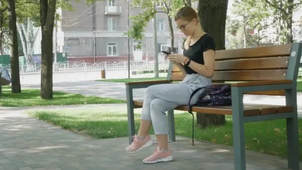 Frau Mit Brille Plaudert Auf Handy Entspanntes Mädchen Sitzt Und — Stockvideo